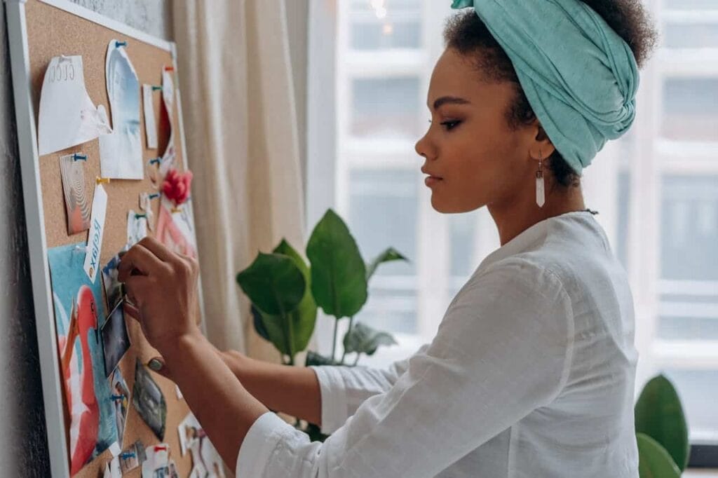 woman adding photos to a bulletin board in an office